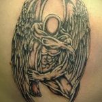 Фото тату ангела на лопатке в стиле blackwork. Ангел с большими крыльями, без лица, выполненный черными чернилами. Идеи для тату.
