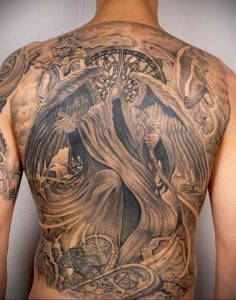 Фото тату ангела-жнеца на спине. Детализированный черно-серый рисунок с множеством элементов, включая черепа, часы и готические мотивы. Подходит для любителей мрачной эстетики.