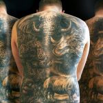 Фото тату на спине: изображение слона, буйвола, леопарда, носорога и льва, выполненное в реалистичной технике с использованием черно-серых тонов.