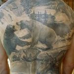 Фото тату на спине: реалистичное изображение диких животных (медведь, волк, олень) в лесной местности, выполненное в черно-серых тонах.