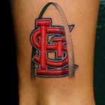 Фото тату на лодыжке: логотип бейсбольной команды Cardinals с изображением арки Gateway Arch. Яркий и детализированный рисунок татуировки.