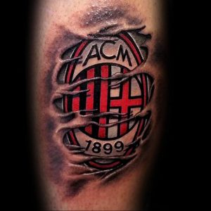 Фото тату с изображением логотипа AC Milan, как будто вырывающегося сквозь кожу. Красные и белые цвета, реалистичный эффект, 3D дизайн.