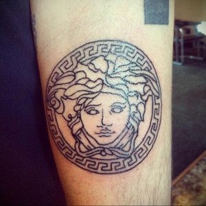Фото тату головы Медузы Горгоны в круге, выполненное в технике blackwork на предплечье. Детализированный рисунок.