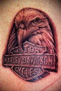 Фото тату с изображением орла и логотипа Harley-Davidson. Черно-белый рисунок татуировки, расположен на груди.