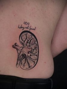 Фото тату на боку с изображением контура почки и надписью '404 kidney not found', выполненное в минималистичном стиле.