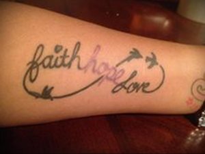 Фото тату: надпись 'Faith Hope Love' в форме бесконечности с летящими птицами. Красивый и символичный рисунок татуировки.