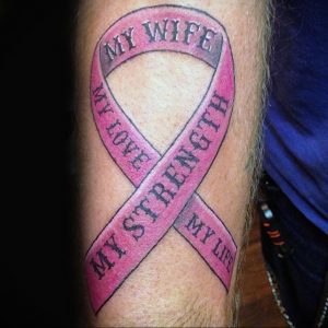 Фото тату на руке: розовая лента с надписями "My Wife", "My Love", "My Strength", "My Life". Символ любви, поддержки и силы.