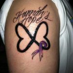 Фото татуировки на плече: надпись 'Hannah's Hope' с изображением клевера и фиолетовой ленты, символизирующей надежду и поддержку.