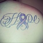 Фото татуировки на плече: изящная надпись 'Hope' с фиолетовой лентой, символизирующей надежду и поддержку. Красивый и вдохновляющий рисунок.