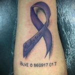 Фото тату: Фиолетовая лента с надписью 'Epilepsia' на предплечье. Татуировка, посвященная борьбе с эпилепсией, с указанием даты.