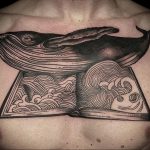 Фото тату на груди: огромный кит выплывает из открытой книги, черно-белая татуировка, детализированный рисунок. Мощный и впечатляющий образ.