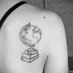 Фото тату на спине с изображением глобуса, стоящего на стопке книг. Минималистичный стиль, четкие линии и лаконичный дизайн.