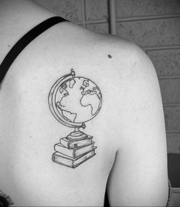Фото тату на спине с изображением глобуса, стоящего на стопке книг. Минималистичный стиль, четкие линии и лаконичный дизайн.