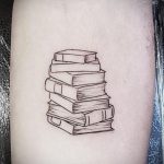 Фото минималистичной татуировки на предплечье, изображающей стопку книг, выполненную тонкими черными линиями. Идеально для любителей литературы.