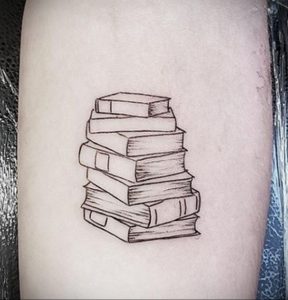 Фото минималистичной татуировки на предплечье, изображающей стопку книг, выполненную тонкими черными линиями. Идеально для любителей литературы.