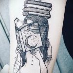 Фото татуировки в стиле dotwork, изображающей девушку, читающую книгу, окруженную планетами и стопкой книг.