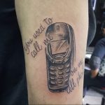 Фото тату: старый кнопочный телефон с надписью "You used to call me on my cell phone". Рисунок выполнен в черно-белом стиле.