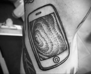 Черно-белая татуировка на руке, выполненная в технике Dotwork. Изображен смартфон с абстрактным узором на экране. Минималистичный и стильный рисунок.