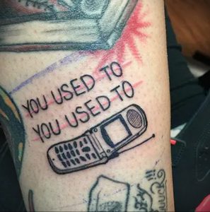 Фото тату на руке: старый кнопочный телефон с надписью 'You Used To' повторяющейся дважды. Рисунок татуировки в стиле минимализм.