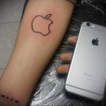 Фото минималистичного тату яблока Apple, выполненного в черном цвете, символизирующего любовь к бренду и технологиям.