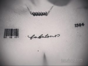 Фото тату штрихкода, надписи 'fabulous' и даты '1984' на груди. Черно-белый рисунок, минималистичный стиль. Символ стиля и года рождения.