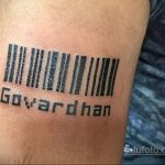 Фото тату штрих-кода с надписью 'Govardhan' на руке. Черный рисунок, четкие линии, простой дизайн.