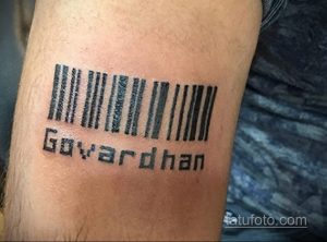Фото тату штрих-кода с надписью 'Govardhan' на руке. Черный рисунок, четкие линии, простой дизайн.