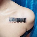 Фото тату штрихкода с датой '0000 2020 0003 11 1982' на ключице. Черно-белый рисунок татуировки.