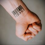 Фото тату на запястье: простой штрих-код с надписью 'doc', выполненный в черном цвете, лаконичный рисунок татуировки.