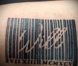 Фото тату штрихкода на теле с римскими цифрами 'VII XIII MCMXCV'. Черно-белый рисунок татуировки, выполненный в минималистичном стиле.