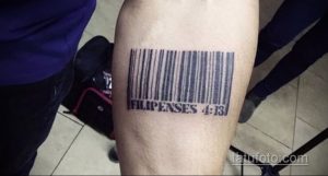 Фото тату штрихкода на предплечье с надписью 'Филиппинцам 4:13'. Черно-белый рисунок татуировки, выполненный четкими линиями.