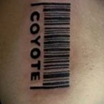 Фото татуировки штрих-кода с надписью "COYOTE". Черно-белый рисунок на коже, символизирующий дикую природу и свободу.