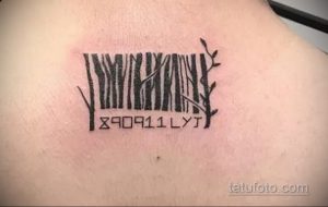 Фото татуировки штрих-кода, из которого растут ветви дерева. Черно-белый рисунок на плече, символизирующий связь с природой.