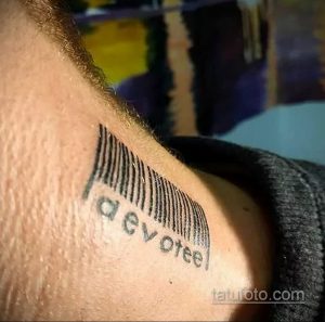 Фото тату на плече: штрихкод с надписью 'devotee'. Символизирует преданность, верность и личные убеждения.