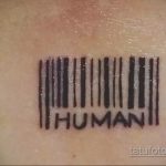 Фото тату штрихкода с надписью 'HUMAN' под ним. Черный рисунок татуировки выполнен в простом и минималистичном стиле.