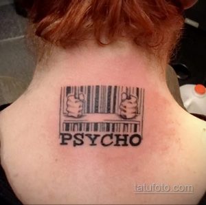 Фото тату штрихкода, сквозь который пробиваются руки, и надпись 'PSYCHO' на затылке. Черно-белый рисунок татуировки выполнен в графическом стиле.