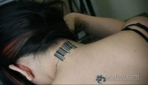 Фото тату штрихкода на шее с небольшими символами. Черно-белый рисунок татуировки, выполненный в минималистичном стиле.