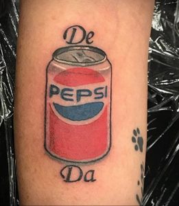 Фото тату банки Pepsi на руке с надписью 'De Da'. Красный, синий и белый цвета, четкий контур. Оригинальный эскиз тату.
