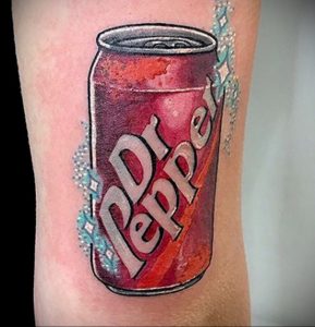 Фото тату: реалистичная татуировка банки Dr Pepper с брызгами напитка. Цветная татуировка на ноге.