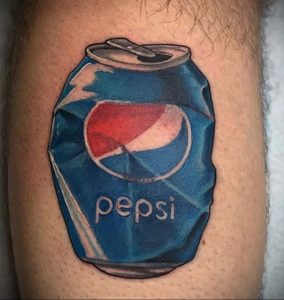 Цветное фото татуировки на ноге с изображением помятой банки Pepsi, выполненной в реалистичном стиле.