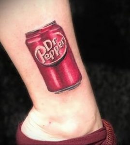 Фото тату: реалистичный рисунок банки Dr Pepper на лодыжке, выполненный в красных и серебристых тонах. Идеально для любителей этого уникального напитка.