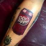 Фото тату реалистичной банки Dr Pepper на предплечье. Красный цвет, детальная прорисовка логотипа и бликов.