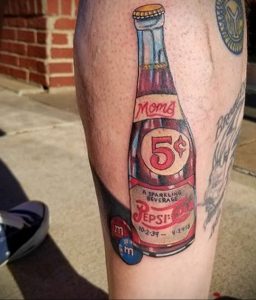 Фото тату старинной бутылки Pepsi с надписью 'Mom' и конфетами M&M's. Красный, белый и желтый цвета, ретро-стиль.