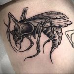 Фото татуировки осы в стиле олдскул на ноге. Яркий рисунок с четкими контурами и насыщенными цветами, характерными для традиционного стиля татуировки.