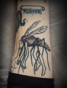 Фото тату на руке: изображение комара и надписи "NOTHING". Черно-белый рисунок татуировки в минималистичном стиле.