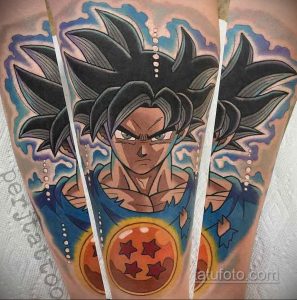 Фото тату на руке с изображением Гоку из аниме "Dragon Ball" в момент использования энергии. Вокруг него яркие вспышки и энергетические волны.