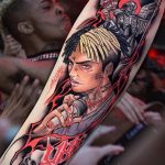 Фото тату XXXTentacion на руке. Детализированный портрет рэпера с использованием ярких цветов и эффекта брызг.