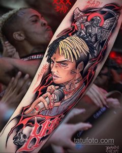 Фото тату XXXTentacion на руке. Детализированный портрет рэпера с использованием ярких цветов и эффекта брызг.