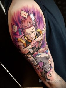 Фото татуировки Киллуа Золдика из аниме Hunter x Hunter на плече. Детализированный рисунок с использованием ярких цветов и изображением игральных карт.