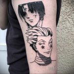 Фото тату Курапики и Леорио из аниме Hunter x Hunter на руке. Черно-белый рисунок с детализированными лицами персонажей.